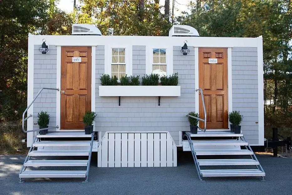 Restroom trailer with entry steps and exterior wash station